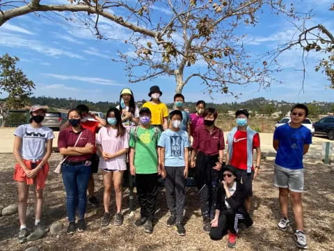 a group of people posing for a photo under a tree