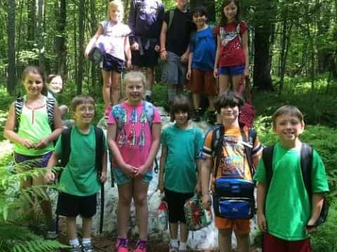 a group of people posing for a photo in the woods