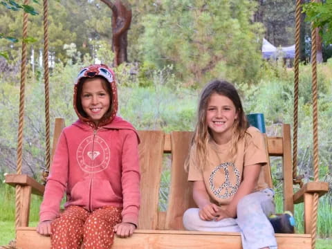 two girls sitting on a bench