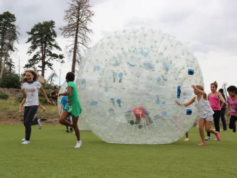 a group of people running towards a large bubble