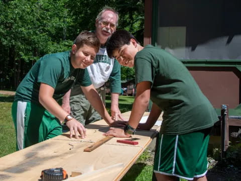 a group of men working on a wood table outside