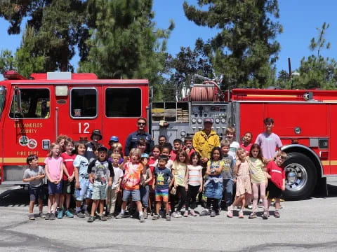 a group of people posing for a photo in front of a fire truck