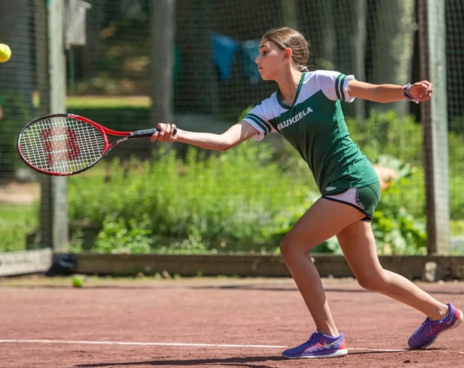 a woman hitting a ball with a tennis racket