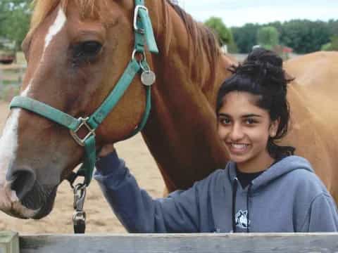 a person smiling next to a horse