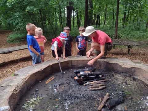 a group of kids standing around a campfire