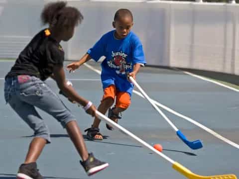 a boy and a girl playing hockey
