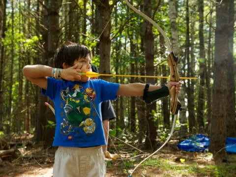 a boy holding a bow and arrow