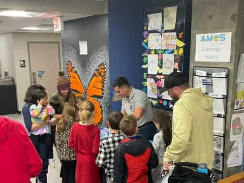 a group of people standing in a room with a kite