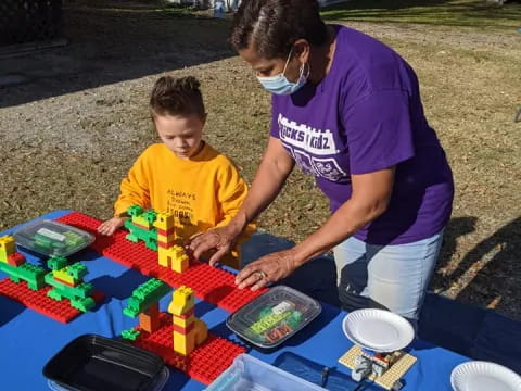 a man and a boy playing with toys on a table