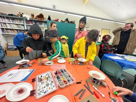 a group of people sitting at a table with food and drinks