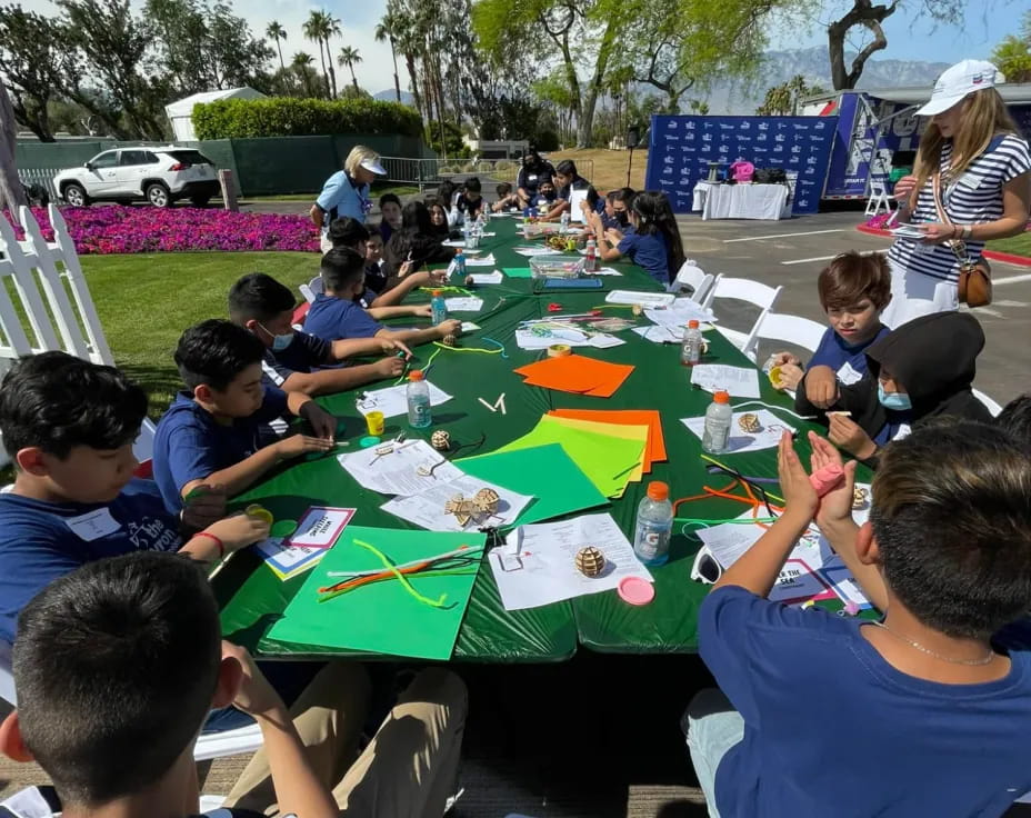 a group of people sitting at a table outside