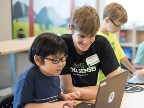 a few young boys working on a laptop