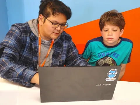 a man and a boy looking at a laptop