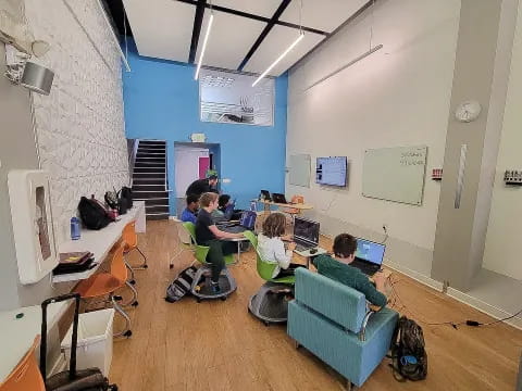 a group of people sitting in a room with computers