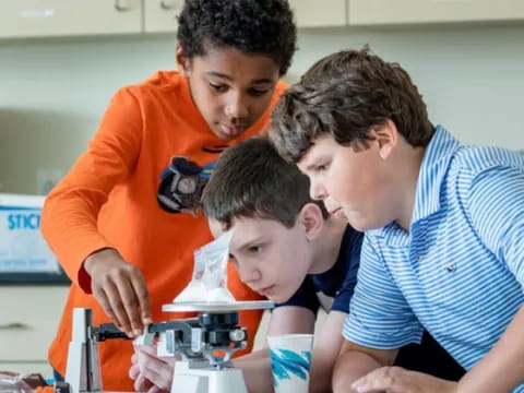 a group of boys looking at a microscope