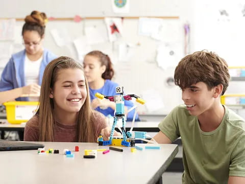 a group of people sitting at a table with a robot