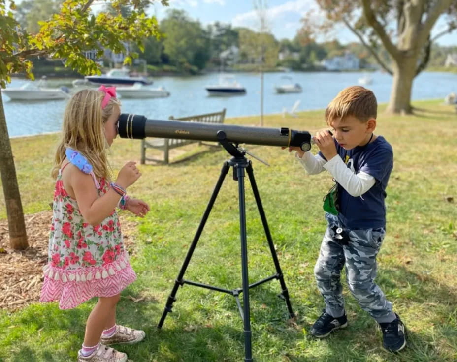 a boy and girl looking at a camera