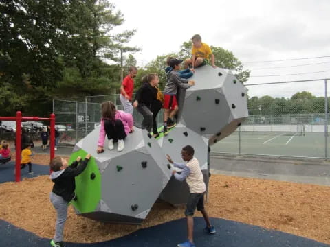 a group of people playing on a large white and black sculpture