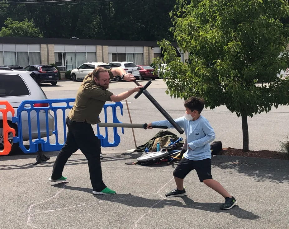 a person pushing a child on a scooter