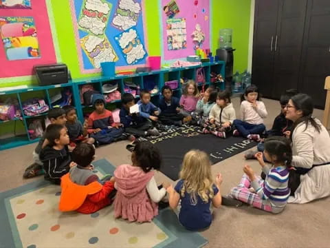 a group of children sitting on the floor in a classroom