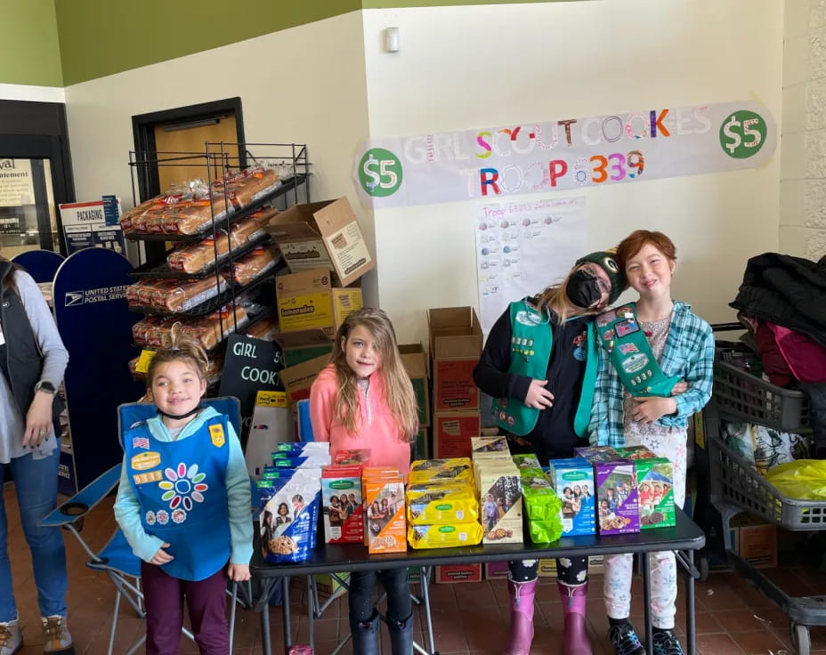 a group of children standing in front of a table with boxes