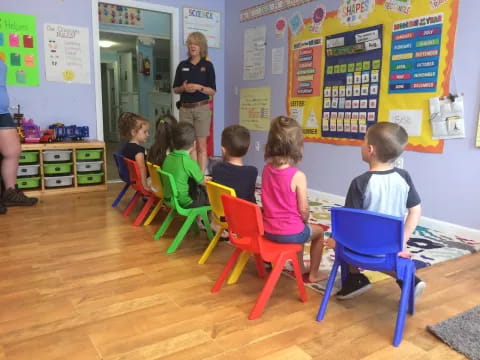 a group of children sitting in chairs