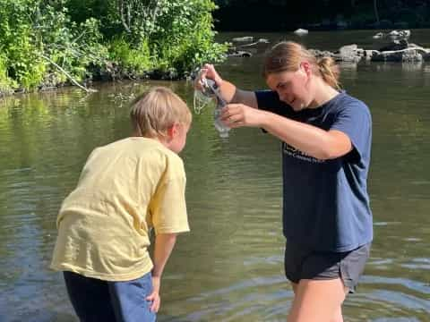 a person and a boy standing in water