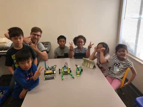 a group of people sitting around a table with toys