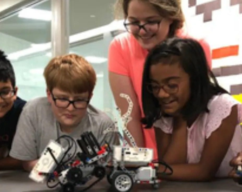 a group of people looking at a toy car