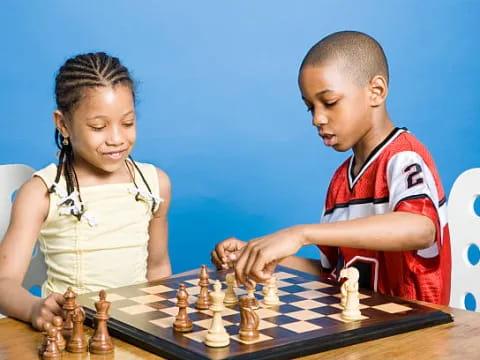 a boy and girl playing chess