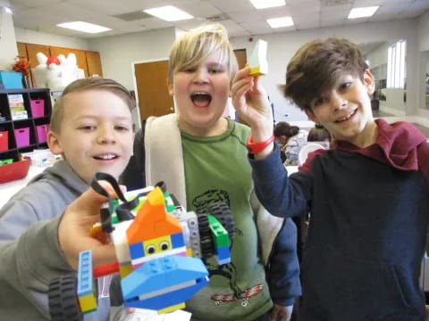 a group of boys holding up a toy