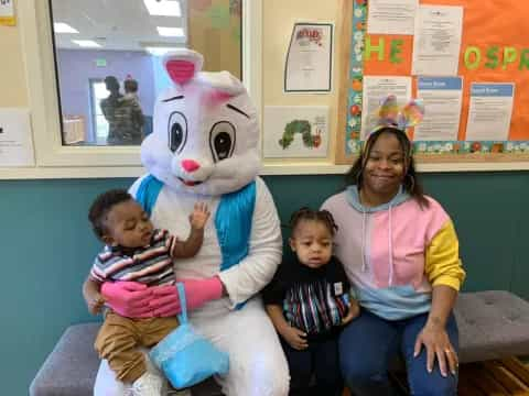 a person and two children sitting next to a person in a garment