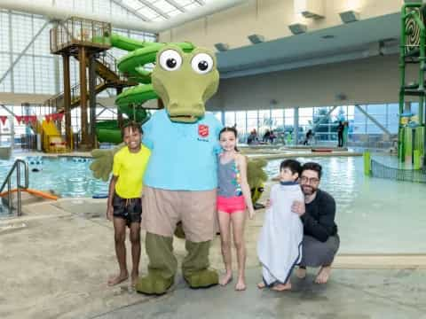 a group of people posing with a person in a frog garment