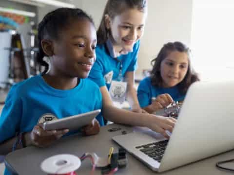 a few young girls working on a laptop