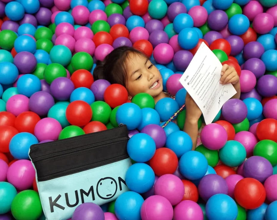 a person lying in a ball pit