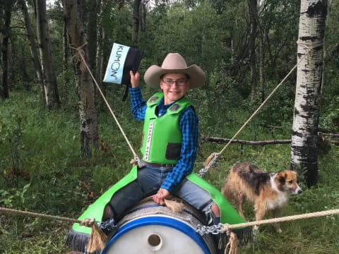 a person in a hat on a raft in the woods with a dog