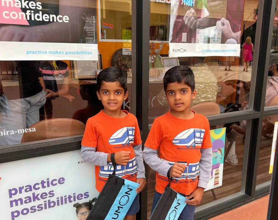 two kids standing next to a sign