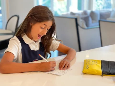 a girl writing on a piece of paper