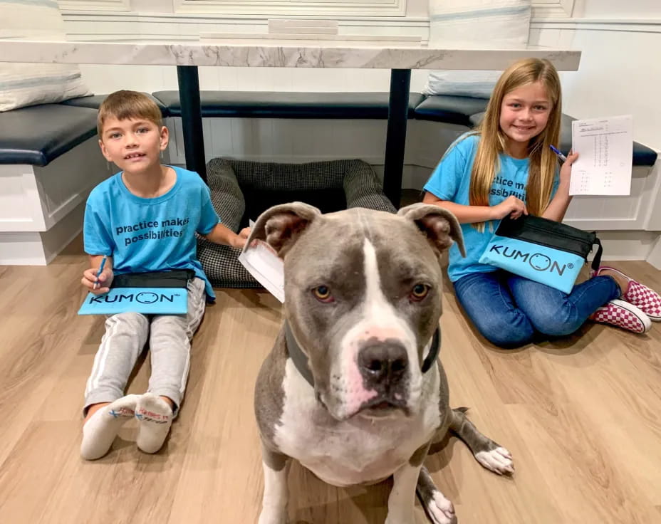 a dog and a couple of children sitting on the floor