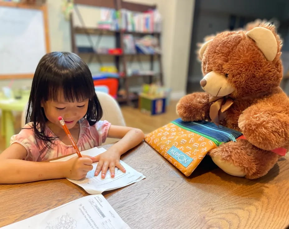 a young girl writing on a book