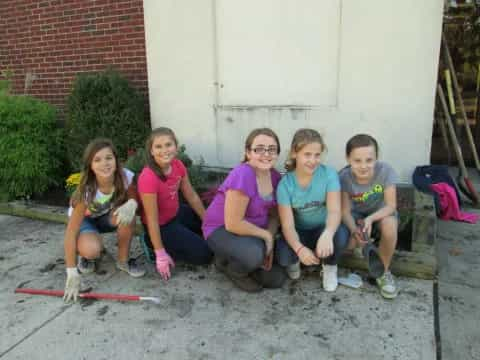 a group of girls sitting on a curb