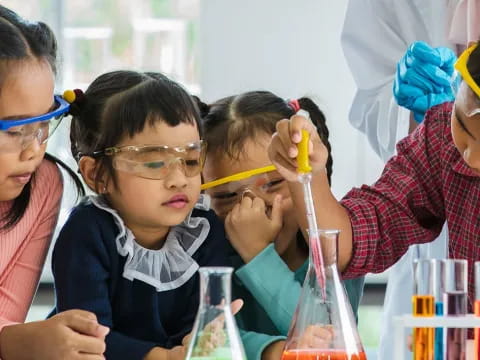 a group of children wearing safety goggles and holding a yellow object