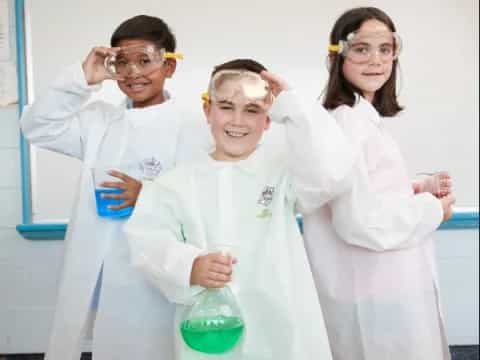 a group of people wearing lab coats and holding beakers