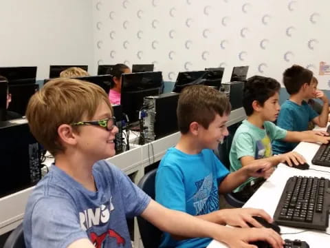 a group of kids sitting at computers