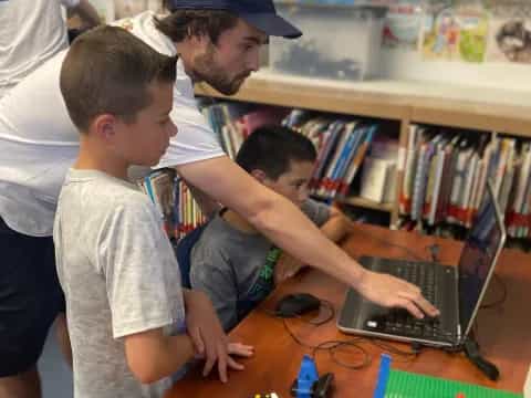 a man and a couple of kids looking at a laptop