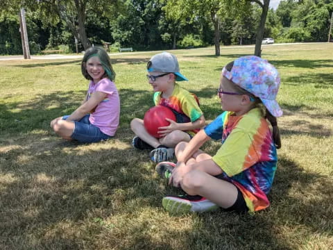 a group of children sitting on the grass