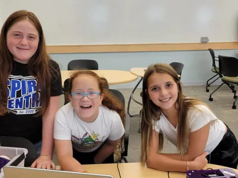 a group of girls sitting at a table