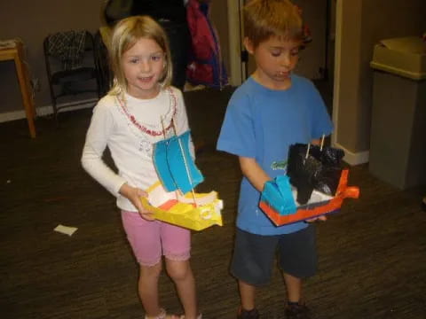 a boy and girl holding a toy