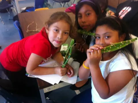 a group of girls holding green objects