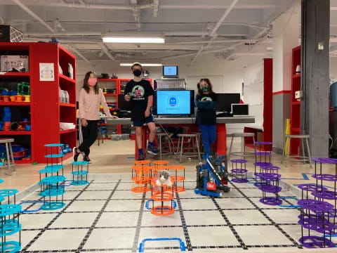 a group of people standing in a room with a television and a table